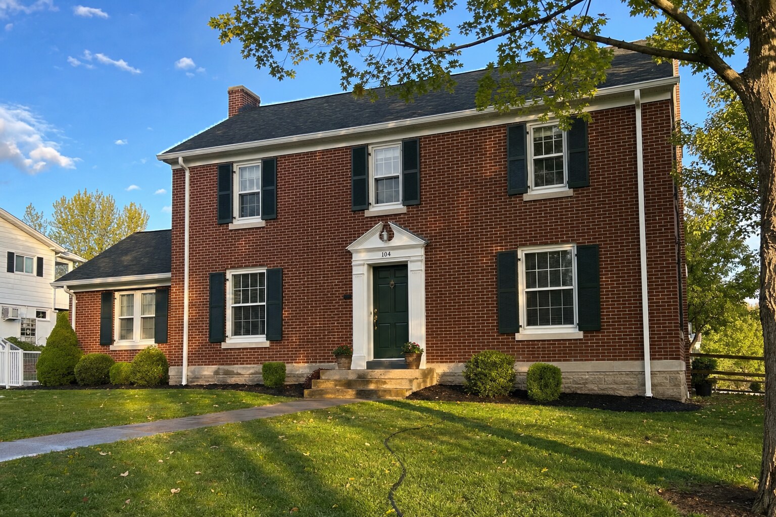 Federal-style red-brick home, freshly soft-washed in late-afternoon light