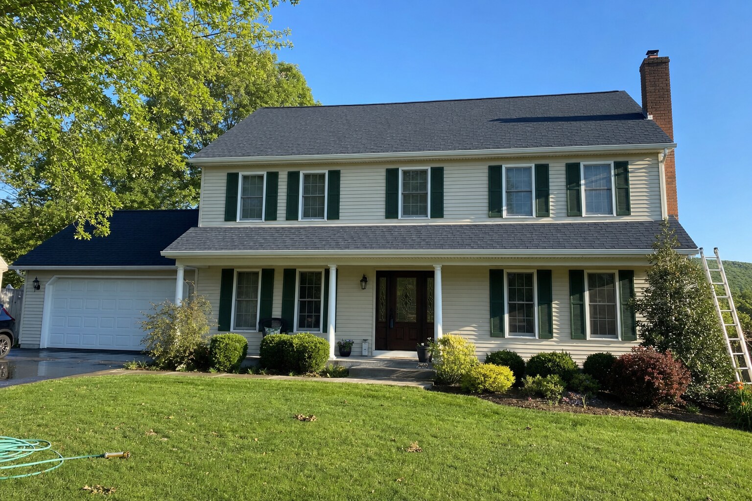 Wide view of a Colonial home with a freshly cleaned, streak-free asphalt shingle roof