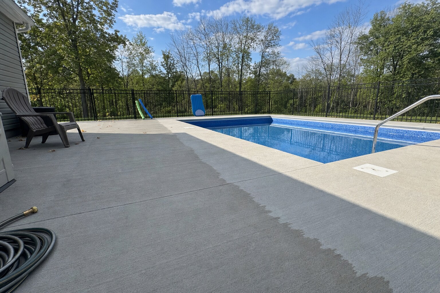 Backyard pool-deck concrete surround freshly cleaned — common multifamily and HOA service