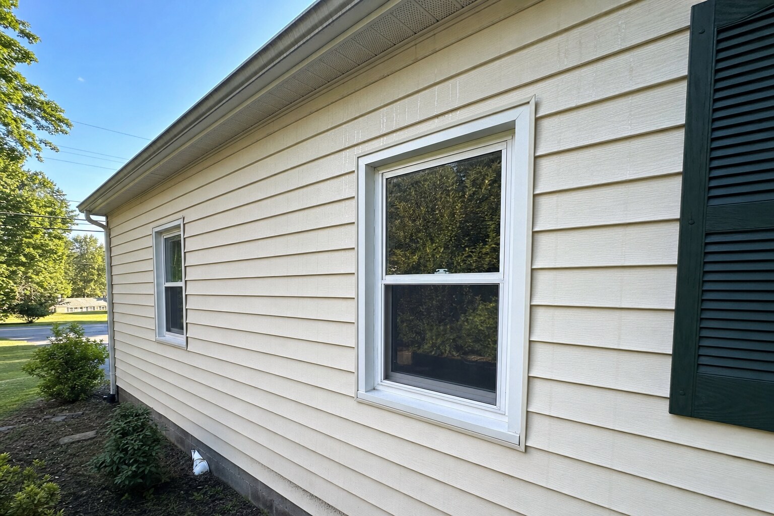 Close-up of cream vinyl lap siding after soft washing, completely free of algae
