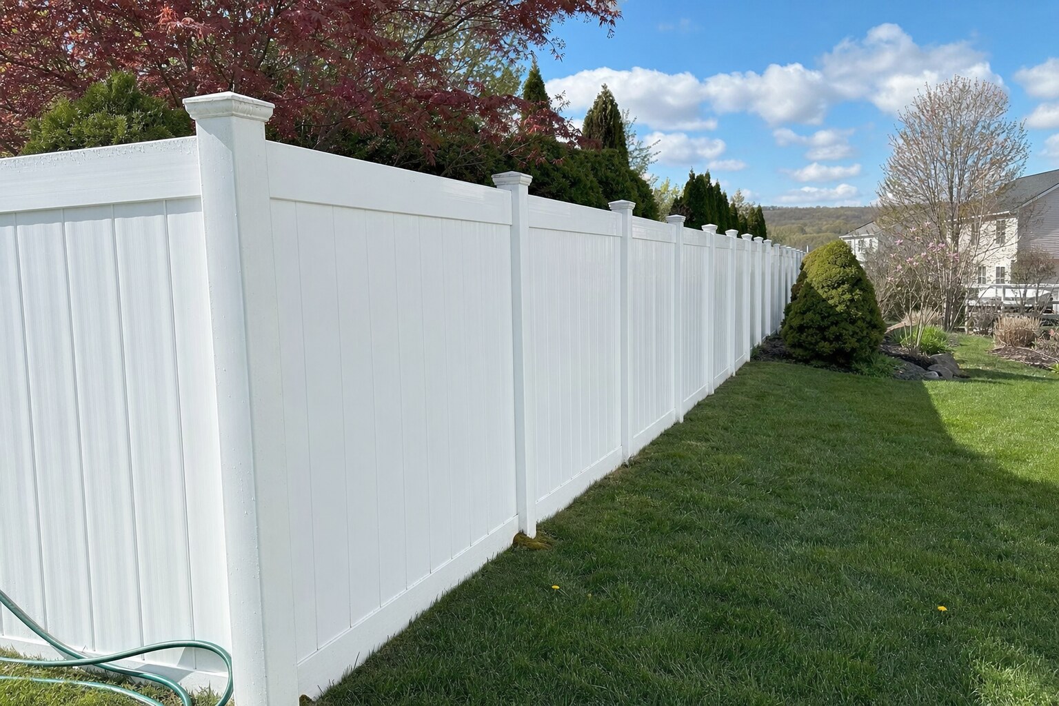 White vinyl privacy fence in Wyoming Borough, PA, freshly soft-washed to restore the original bright finish