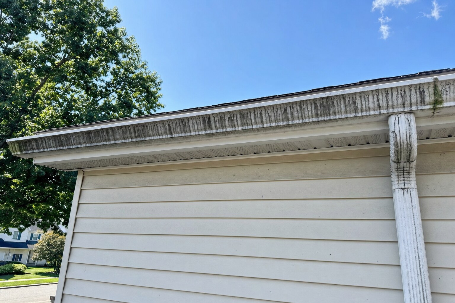 White aluminum gutter face with heavy black tiger-stripe streaks